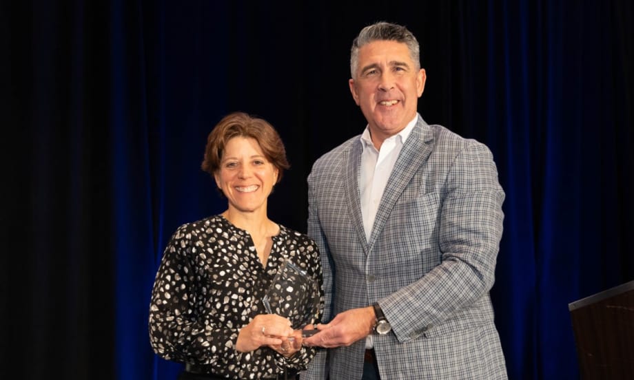 Sandra Doucetter (left) and Mike Joyce (right) post on stage with the 2024 Fleet Safety Award.