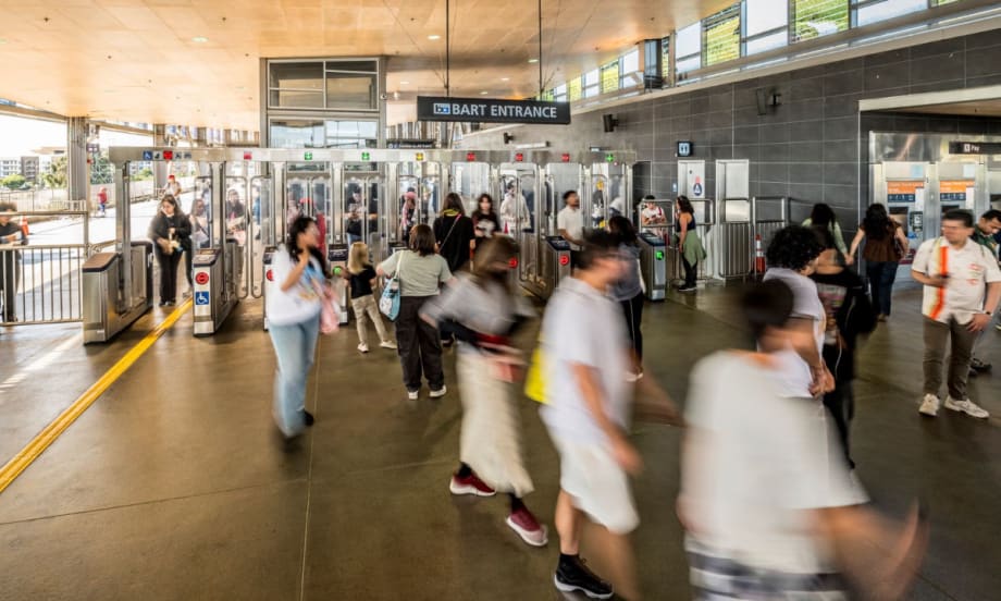 Riders pass through a BART entrance.