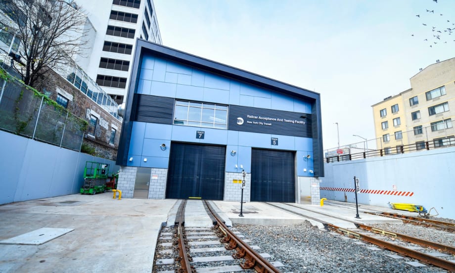 Exterior view of the Railcar Acceptance and Testing Facility with tracks leading into the closed bay doors.