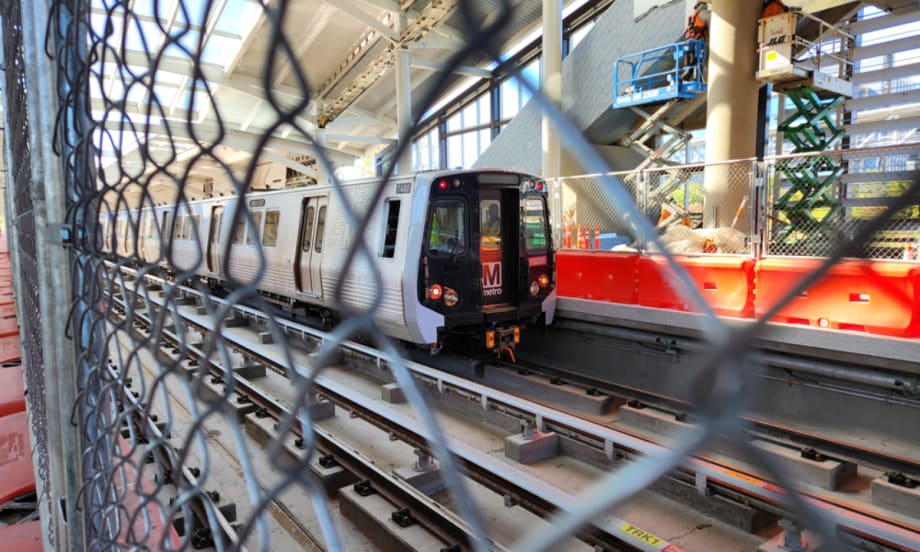 A WMATA train through a chain link fence.