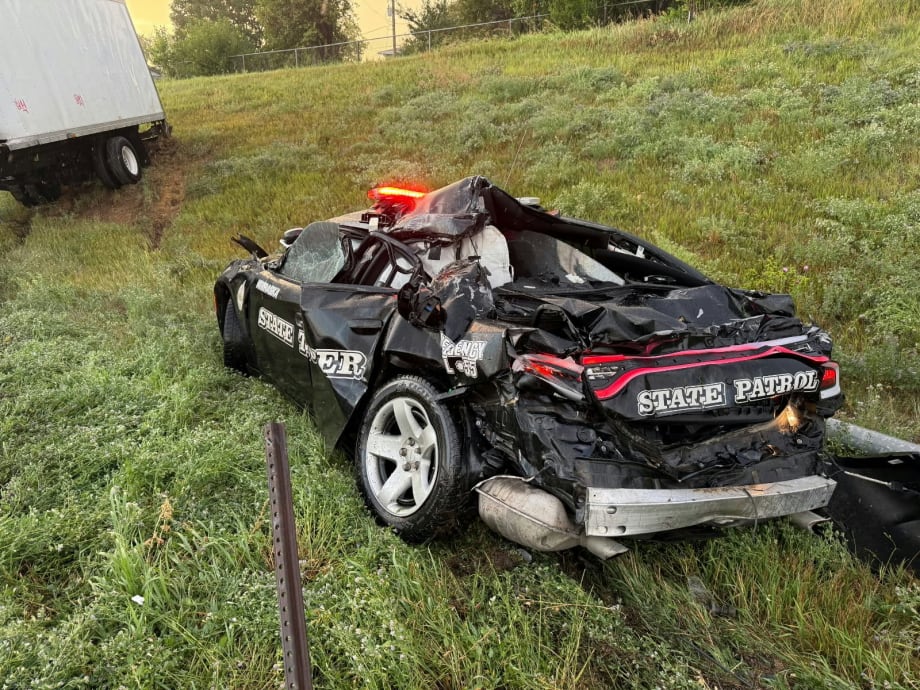 Severely damaged State Patrol police car crashed on grassy roadside