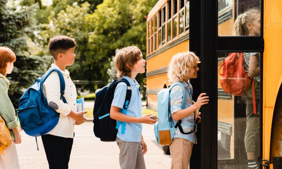 Five students board a school bus.