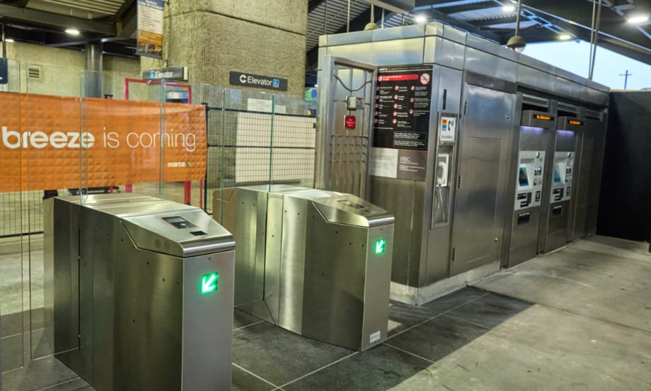Image of fare gates with an orange sign reading "A better breeze is coming."