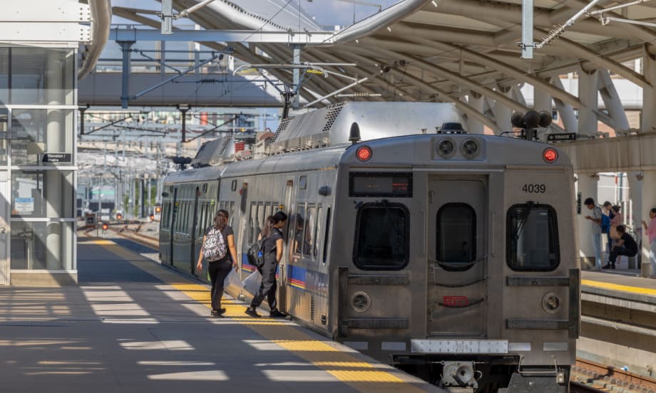 Passengers at a station boarding an RTD train.