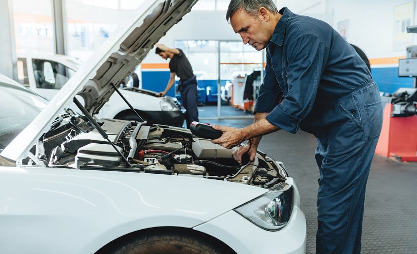 A man working on the engine of a car.