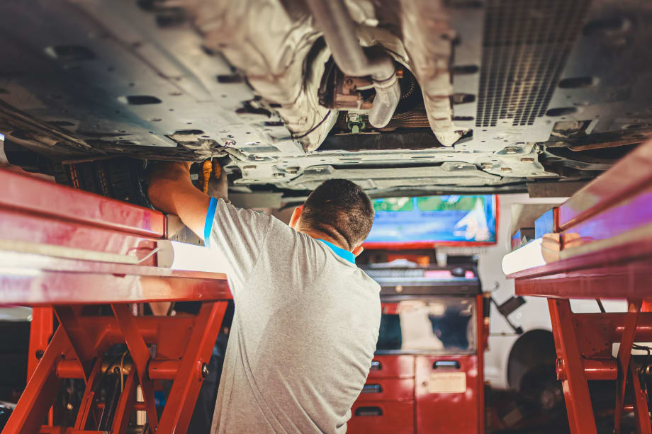 man performing maintenance under a car