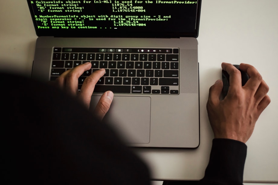 Person at laptop with green-colored code on the screen