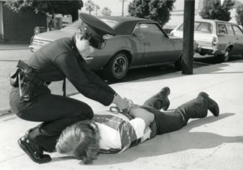 A female police officer makes an arrest in the 1980s. Photo courtesy of Los Angeles Police Historical Society.