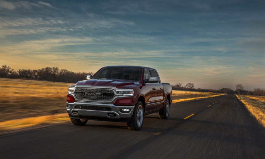 A maroon Ram 1500 Limited drives down a highway.