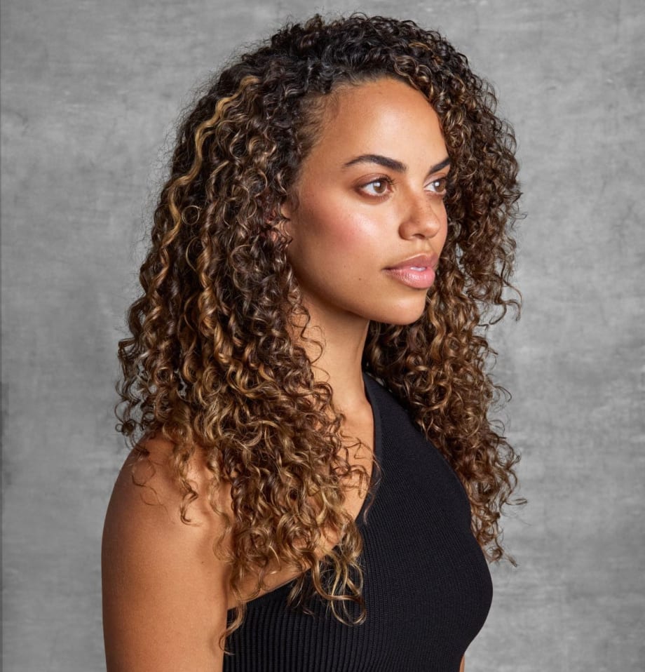 woman with brown, curly hair, in profile