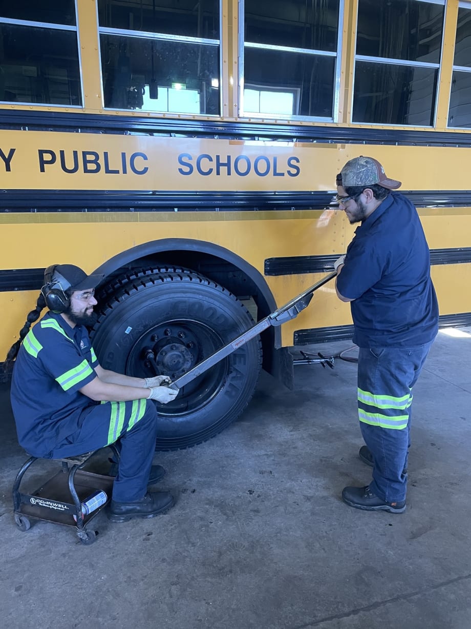 two men work on a school bus