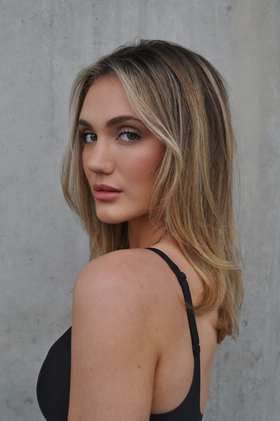 Young woman with medium-length, silky hair featuring multidimensional highlights and shine.