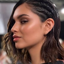 A model in profile with short dark hair.