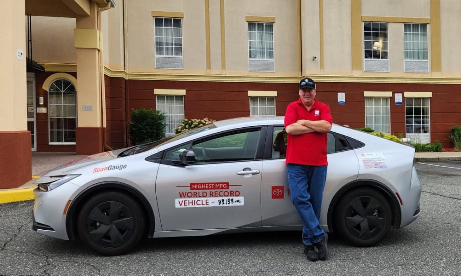 Wayne Gerdes poses in front of the Toyota Prius he drove across the country.