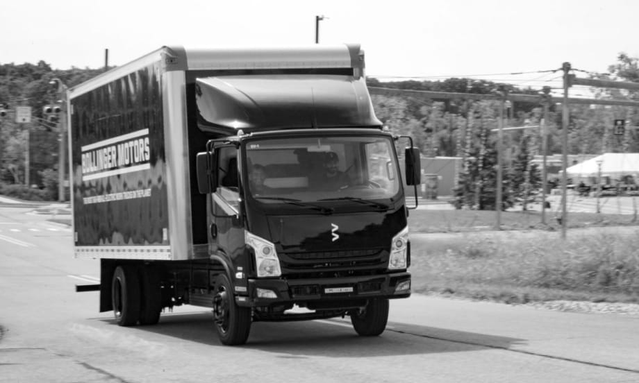 A black and white image of Bollinger B4 EV truck driving on a road.