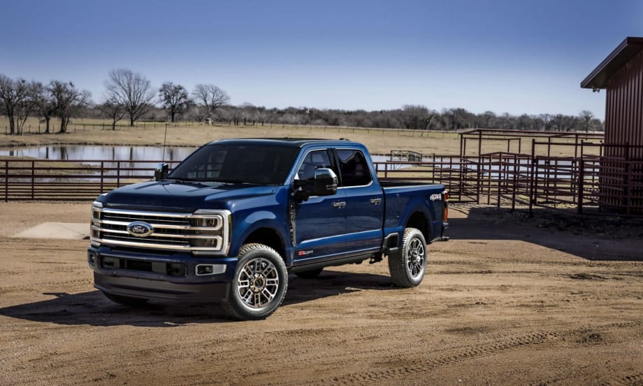 A 2025 Ford F-350 Platinum Plus in Antimatter Blue parked on farm land.