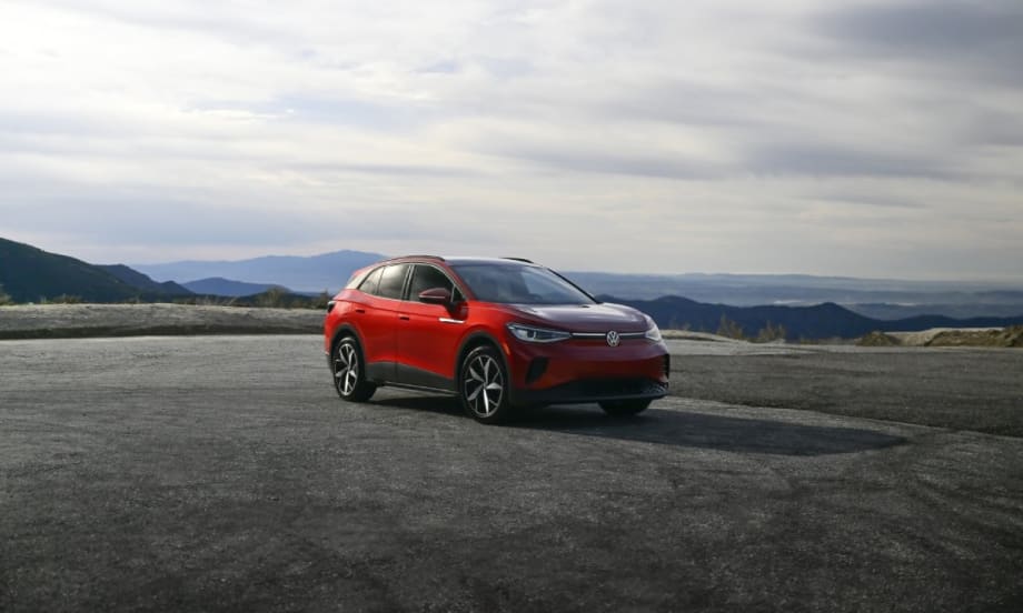 A red Volkswagen ID.4 with mountains on the horizon.