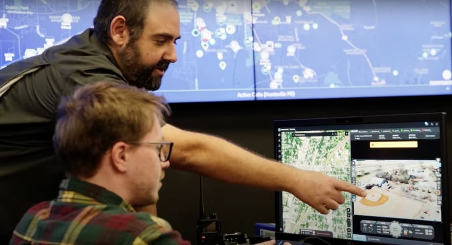 Analysts reviewing geospatial data on multiple computer screens in a monitoring center