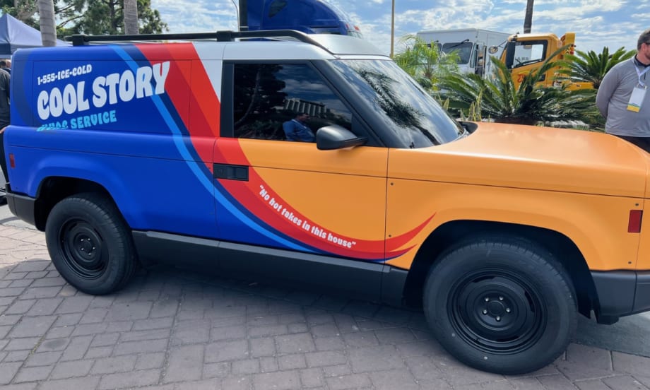 A side view of the yellow, blue, and red Slate Auto electric pick-up truck and SUV