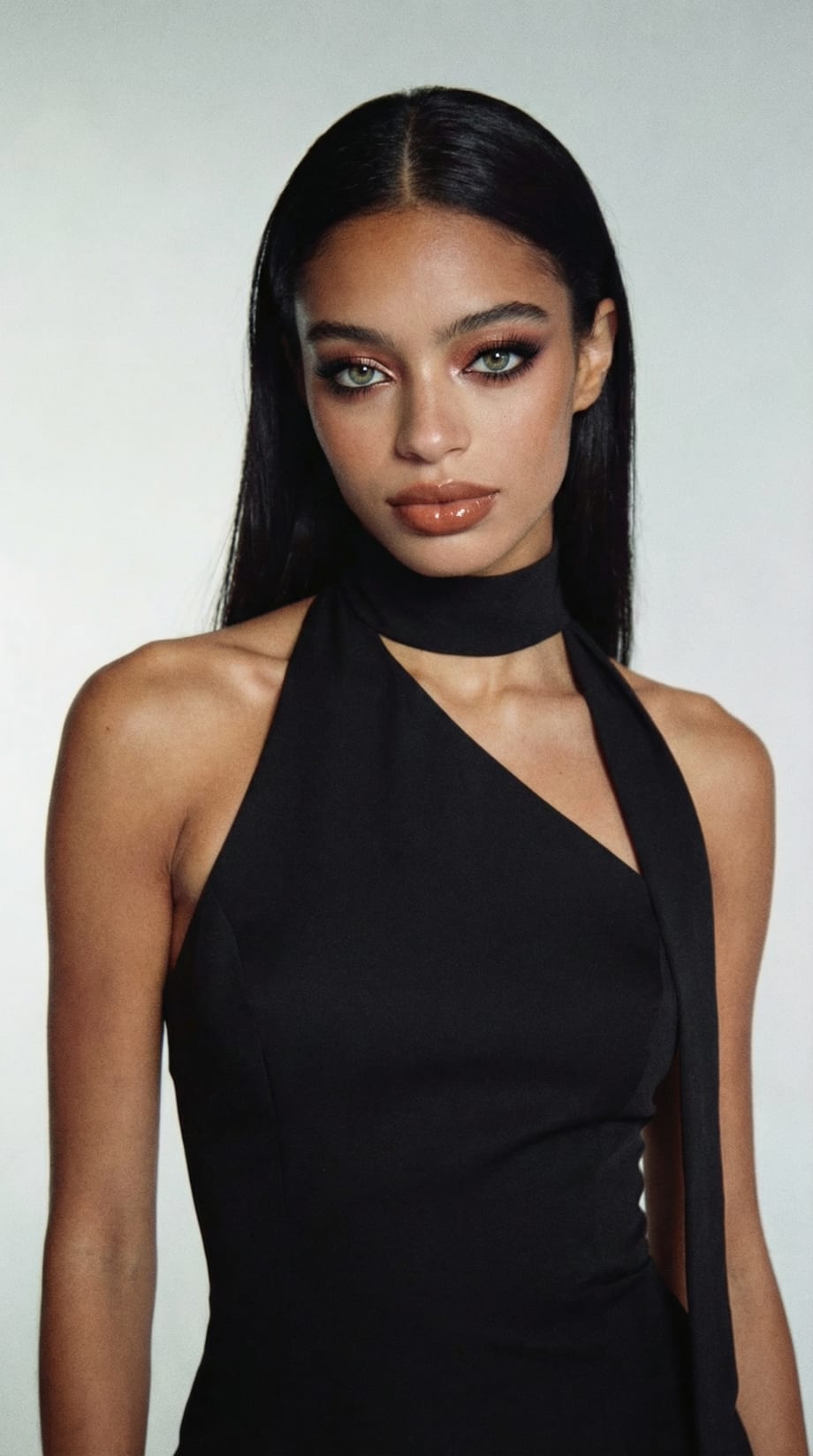 A model with very dark brunette hair in a black sleeveless top.