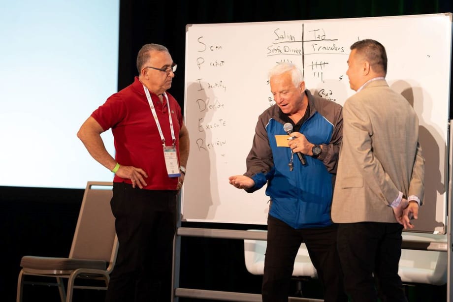 ImprovLearning instructor Steve Verret on stage with two fleet managers.