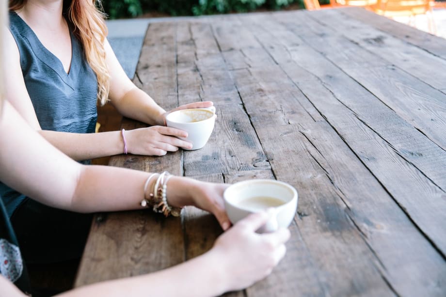 Two people holding cups. Only arms are visible.