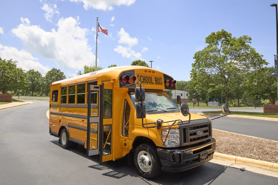 a thomas built type a minotour school bus is shown parked outside on a sunny day