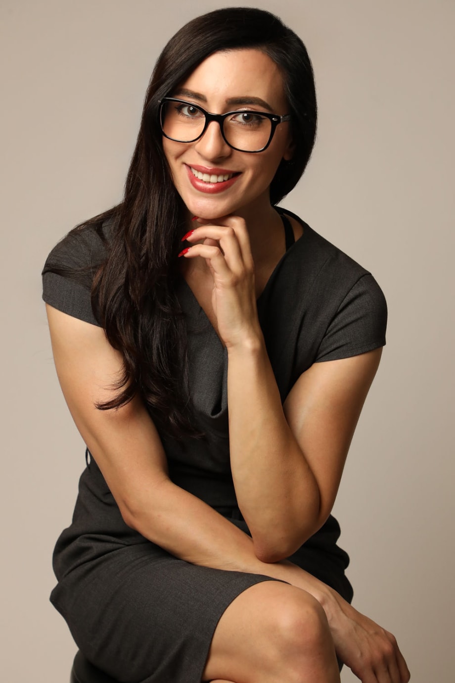 A smiling woman sitting on a chair.