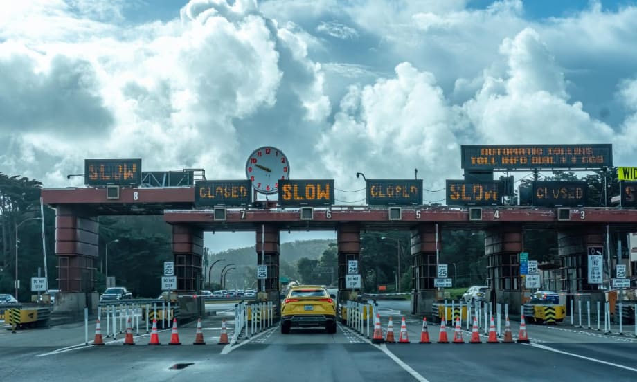 A toll plaza beneath partly sunny cumulonimbus clouds.