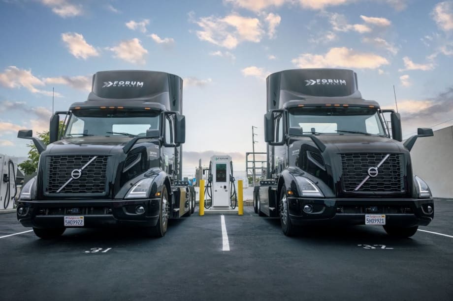 photo of two Volvo electric trucks at a Forum Mobility charging station