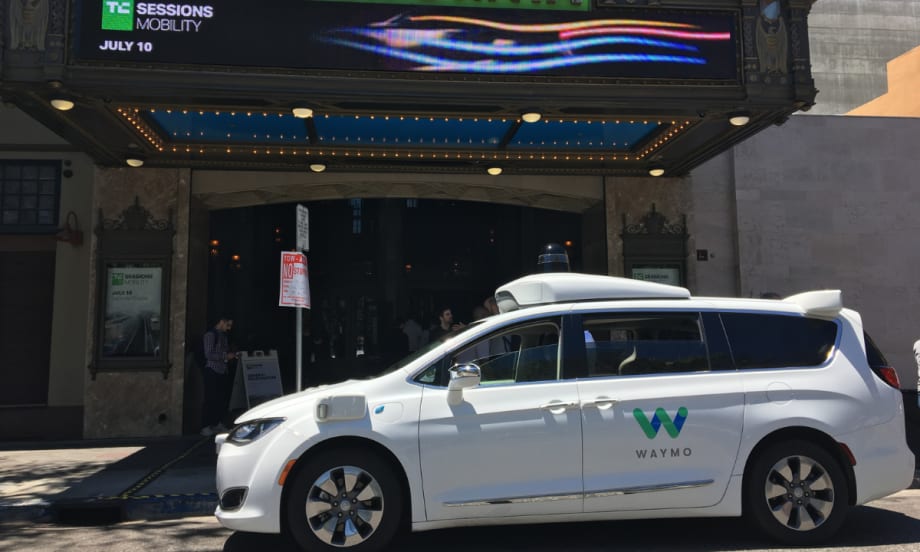 Waymo minivan in front of a theater.