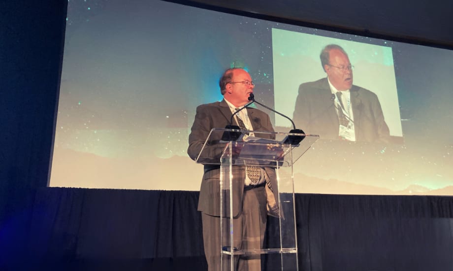 Photo of Mike Antich on stage addressing audience