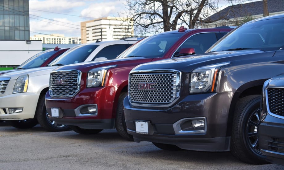 A row of GMC SUVs on a used car lot.