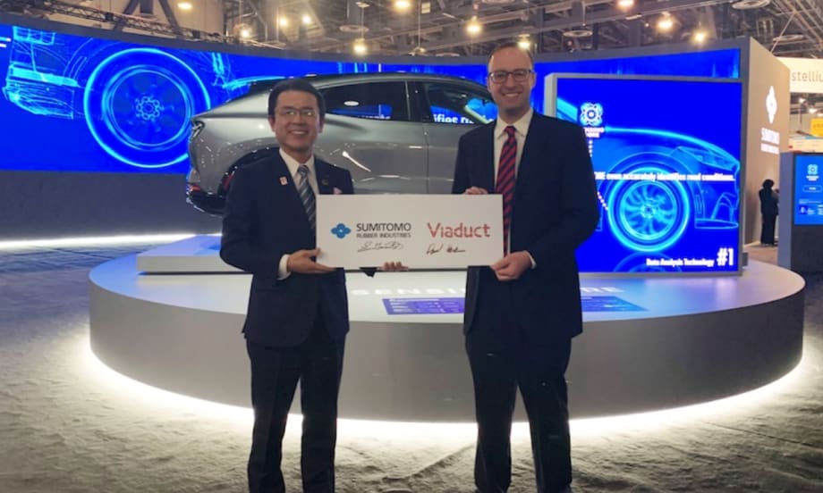 Two people pose with a sign symbolizing Viaduct's partnership with SRI.