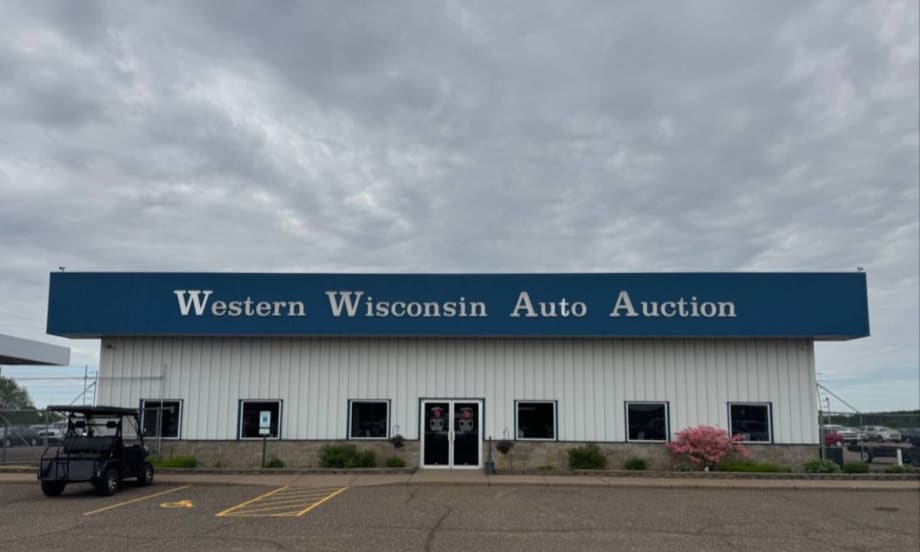 The front of the main building at Western Wisconsin Auto Auction on a cloudy day.