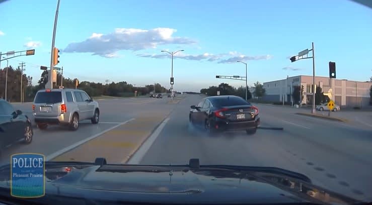 Police dashcam view of intersection with traffic and vehicles