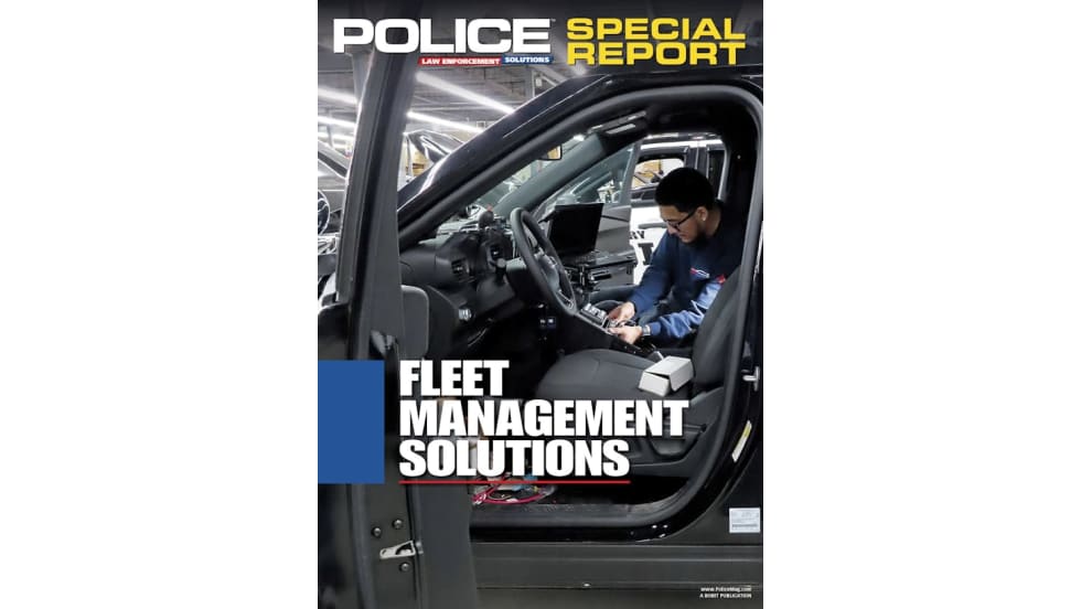 A technician installs equipment inside a black police vehicle in a garage or factory setting. The image is overlaid with the title text “Police Special Report: Fleet Management Solutions.”