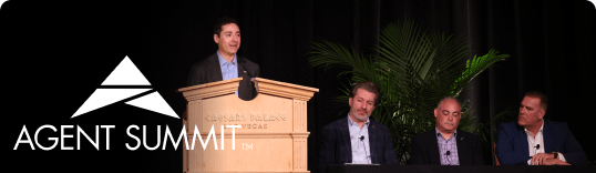 Presenter speaking at a podium during Agent Summit, with panelists seated beside him on stage